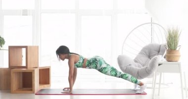 Kalas pozisyonunda duran konsantre olmuş zayıf siyahi kadın. Kendinden emin Afro-Amerikan sporcu kadın eğitiminin portresi..