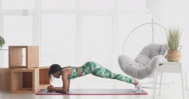 Kalas pozisyonunda duran konsantre olmuş zayıf siyahi kadın. Kendinden emin Afro-Amerikan sporcu kadın eğitiminin portresi..