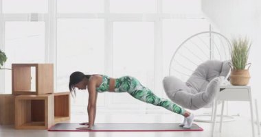 Kalas pozisyonunda duran konsantre olmuş zayıf siyahi kadın. Kendinden emin Afro-Amerikan sporcu kadın eğitiminin portresi..