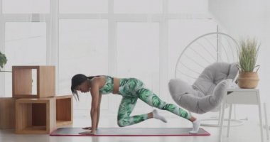 Kalas pozisyonunda duran konsantre olmuş zayıf siyahi kadın. Kendinden emin Afro-Amerikan sporcu kadın eğitiminin portresi..