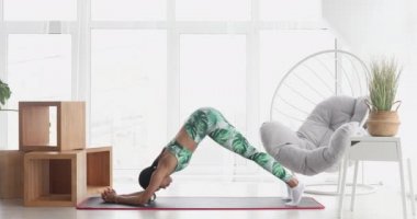 Kalas pozisyonunda duran konsantre olmuş zayıf siyahi kadın. Kendinden emin Afro-Amerikan sporcu kadın eğitiminin portresi..