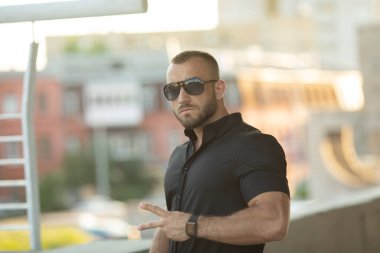 Dışarıda güneş gözlüklü güzel ve çekici bir adamın portresi..