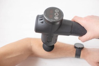 Masör masaj egzersizleri yapıyor. Spor vücut masajı için perküsyon terapisi. Spor yaralarının iyileşme kavramları.
