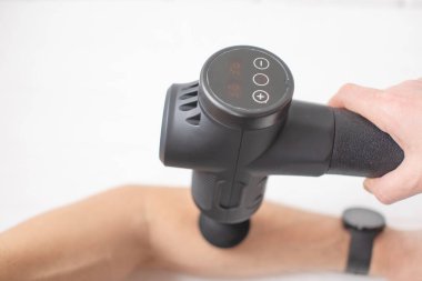 Masörün masaj egzersizleri yaparken kısmi görüntüsü. Spor vücut masajı için perküsyon terapisi. Spor yaralarının iyileşme kavramları.