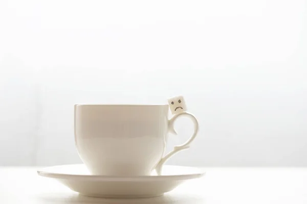 stock image Close-up view of white sugar cube on cup of coffee. Smile. Concept.