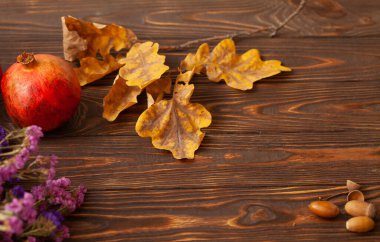 Nar ve kuru yapraklarla dolu ahşap bir masada sonbahar sakin bir hayat.