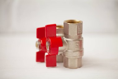 Tahta arka planda kırmızı saplı su topu vanalarının yakın görüntüsü.