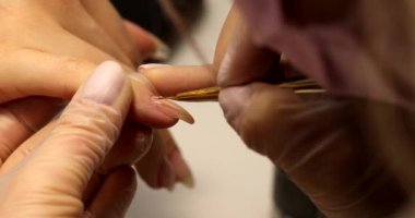 Güzellik salonunda manikürcü müşteriyi tedavi ediyor. Manikür, çivi boyama. Ellerin yakın çekimi