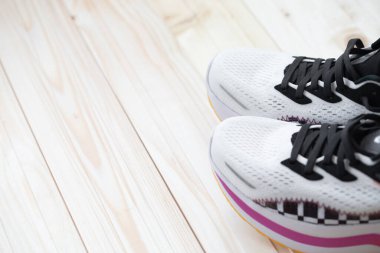 Açık ahşap arka planda spor ayakkabıların yakın çekim görüntüsü. Şık beyaz ayakkabılar.