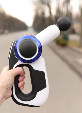 Elinde terapi amaçlı masaj tabancası tutan biri.