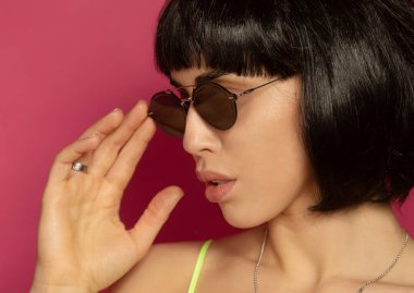 Güzellik mankeni kız portresi. Bob siyah saç stili. Esmer kadın pembe arka planda poz veriyor..