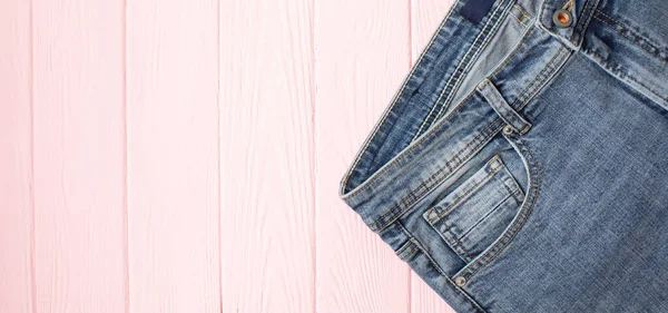 Top View Fashionable Jeans Pink Wooden Background Copy Space — Stock Photo, Image