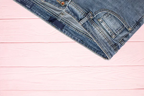 Top View Fashionable Jeans Pink Wooden Background Copy Space — Stock Photo, Image