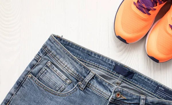 Top View Stylish Denim Pants Orange Sneakers Light Wooden Background — Stock Photo, Image