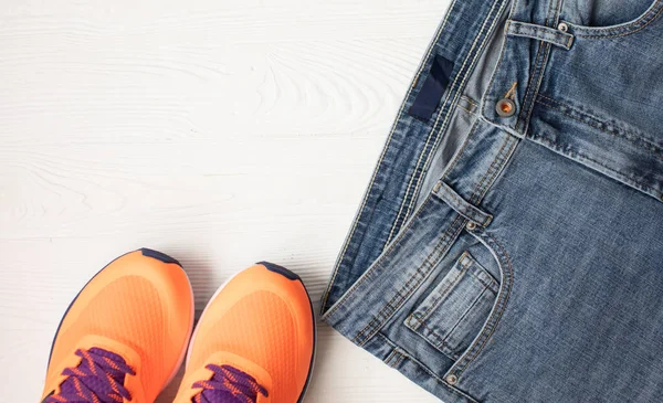 Top View Stylish Denim Pants Orange Sneakers Light Wooden Background — Stock Photo, Image