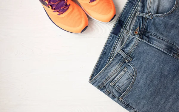 Bovenaanzicht Van Stijlvolle Denim Broek Oranje Sneakers Lichte Houten Achtergrond — Stockfoto