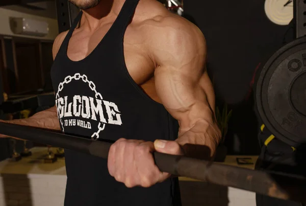 근육질의 남자가 근육질에서 바벨을 훈련시키는 발견되었습니다 — 스톡 사진