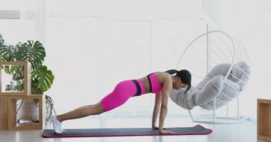 Sporcu fit kız oturma odasında aerobik egzersizleri yapıyor. Ev sağlığı ve sağlık konsepti.