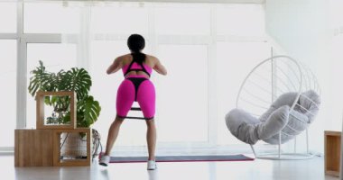 Atletik Afrikalı Amerikalı güzel bir kadın spor yaparken spor yaparken spor yaparken spor yaparken elastik bir bant kullanıyor..