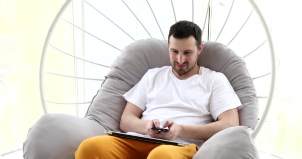 Sorrindo Jovem Adulto Homem Usando Smartphone Laptop Computador Casa — Vídeo de Stock