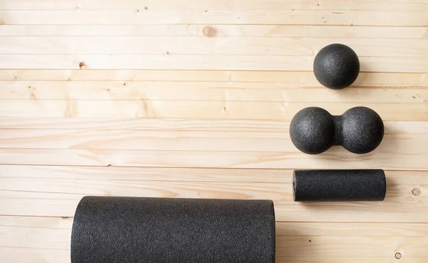Foam roll, massage roll, balls on wooden background