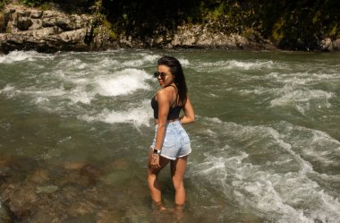 Genç zenci kadın turist nehirde dinleniyor.