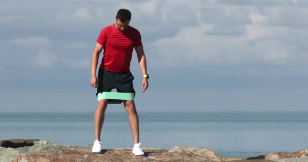Junger Fitness Kaukasier Macht Der Küste Übungen Mit Gummiband — Stockvideo