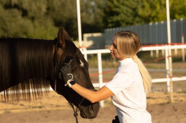 Genç bir kadın binicilik ve sürtünme atı olmaya hazırlanıyor.