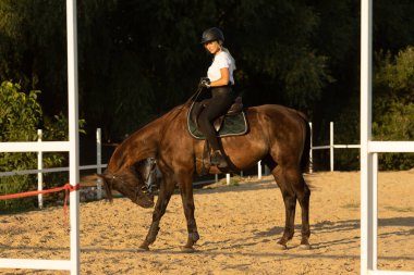 Çekici, gülümseyen genç bir kadın ata biniyor