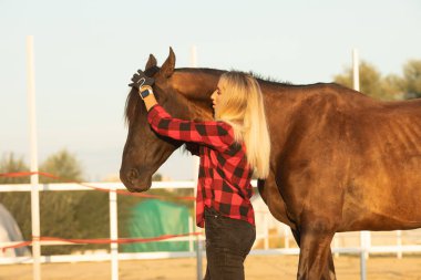 Kırmızı kareli gömlekli çekici genç kadın çiftçi atıyla, insanlar ve hayvanlar arasındaki aşk kavramı