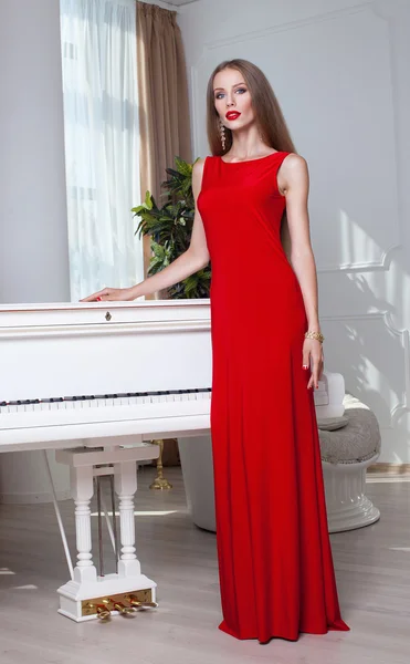Bella donna bruna in un vestito rosso. Colpo in studio. Capelli lunghi. Labbra rosse . — Foto Stock