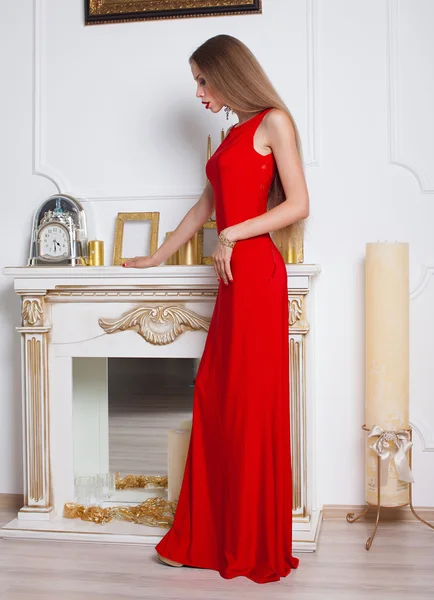 Elegante sensuale giovane donna in abito rosso sul recamier tiro al coperto — Foto Stock
