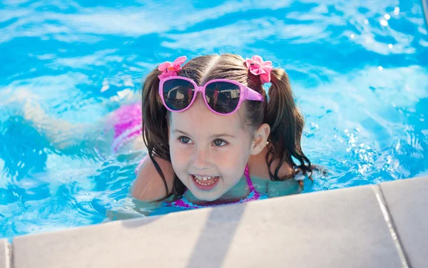 Glückliches Kind, das im Schwimmbad spielt. Sommerferienkonzept — Stockfoto