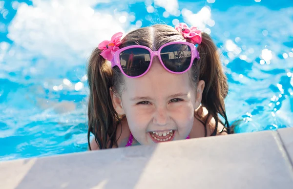 Glückliches Kind, das im Schwimmbad spielt. Sommerferienkonzept — Stockfoto