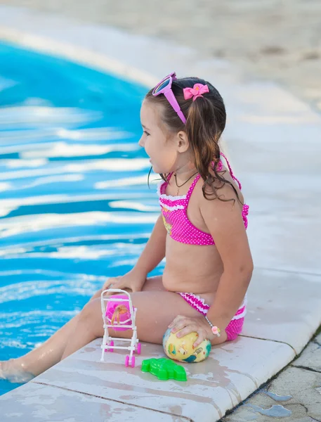 Glückliches Kind, das im Schwimmbad spielt. Sommerferienkonzept — Stockfoto