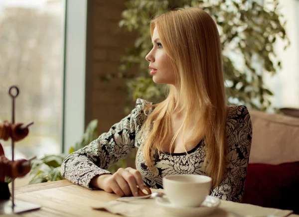 Portrait of a cute blonde smiling woman sitting in a cafe — Stock Photo, Image