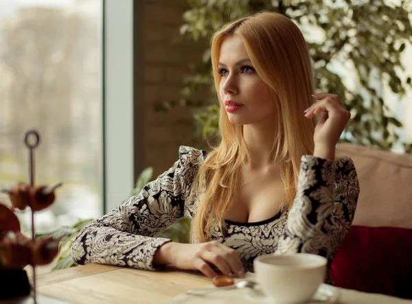 Портрет милой блондинки, улыбающейся женщине, сидящей в кафе — стоковое фото