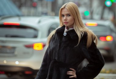 Genç gülümseyen kadın açık havada dikey. Yumuşak güneşli renkler. Yakın portre. Güzel bir genç sarışın kış portresi