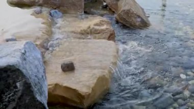 Güneşli bir günde taşların üzerinden akan su