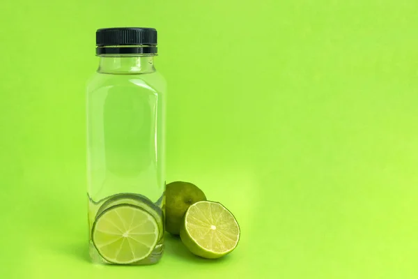 Bottle Water Slices Lime Light Green Background Copy Space — Stock Photo, Image
