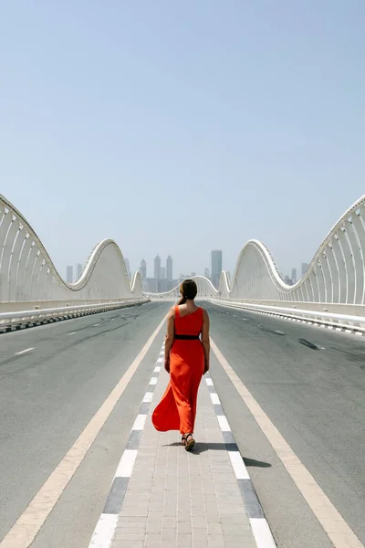 Uma Mulher Vestido Vermelho Laranja Andando Por Uma Estrada Vazia Fotografias De Stock Royalty-Free