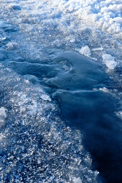 Frozen stream in the rays of the spring morning sun