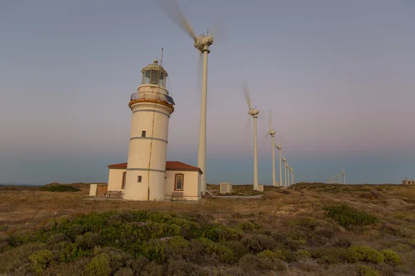 Ветряные турбины генерирующие чистую энергию с маяком — стоковое фото