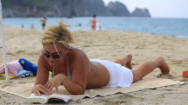 Blonde vrouwen lezen van een boek — Stockvideo