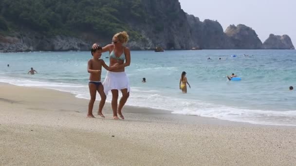 Mutter und Sohn spazieren am Strand — Stockvideo