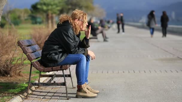 Mujeres rubias tristes sentadas en un banco — Vídeos de Stock