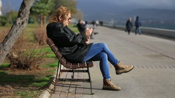 Aantrekkelijke blonde zitten bank en het gebruik van tablet pc — Stockvideo