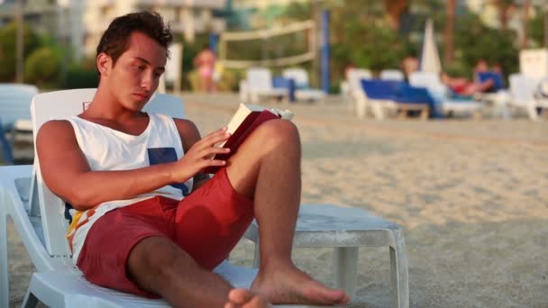 Aantrekkelijke jonge man lezen van een boek — Stockvideo