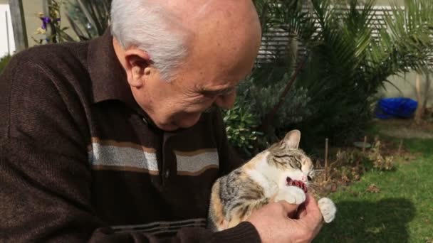 Starszy mężczyzna grający kot w ogrodzie 2 — Wideo stockowe