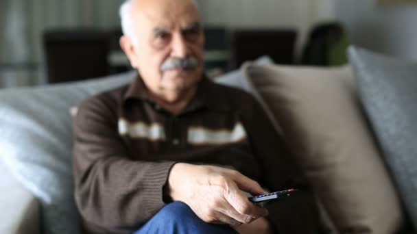 Homme âgé Regarder la télévision et utiliser la télécommande à la maison — Video